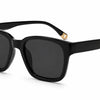 Black square sunglasses by Fox Shades with a glossy black frame, dark smoke lenses, wide arms, and gold-toned temple tips